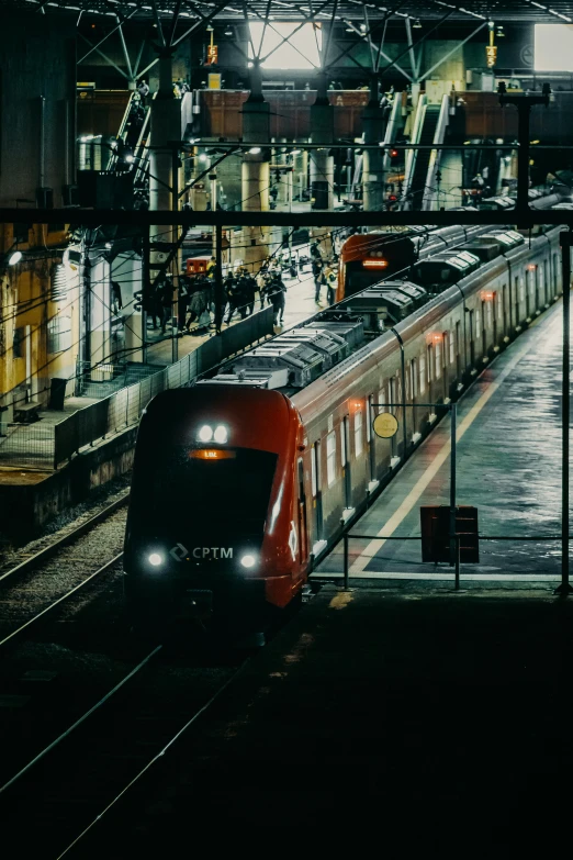 a large long train on a steel track, by Jens Søndergaard, pexels contest winner, renaissance, city at night in the rain, square, red and black color scheme, train station in summer