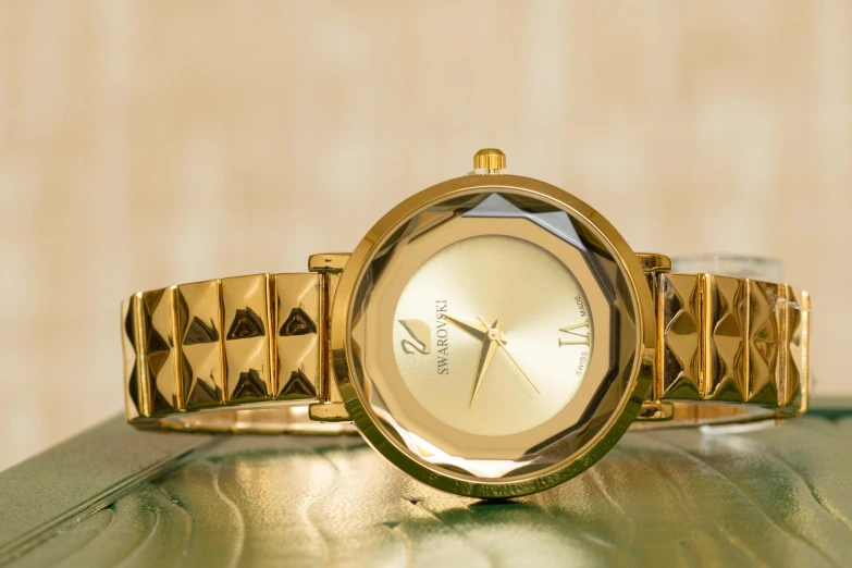 a close up of a wrist watch on a table, by Julia Pishtar, shades of gold display naturally, thumbnail, plutus su, faceted