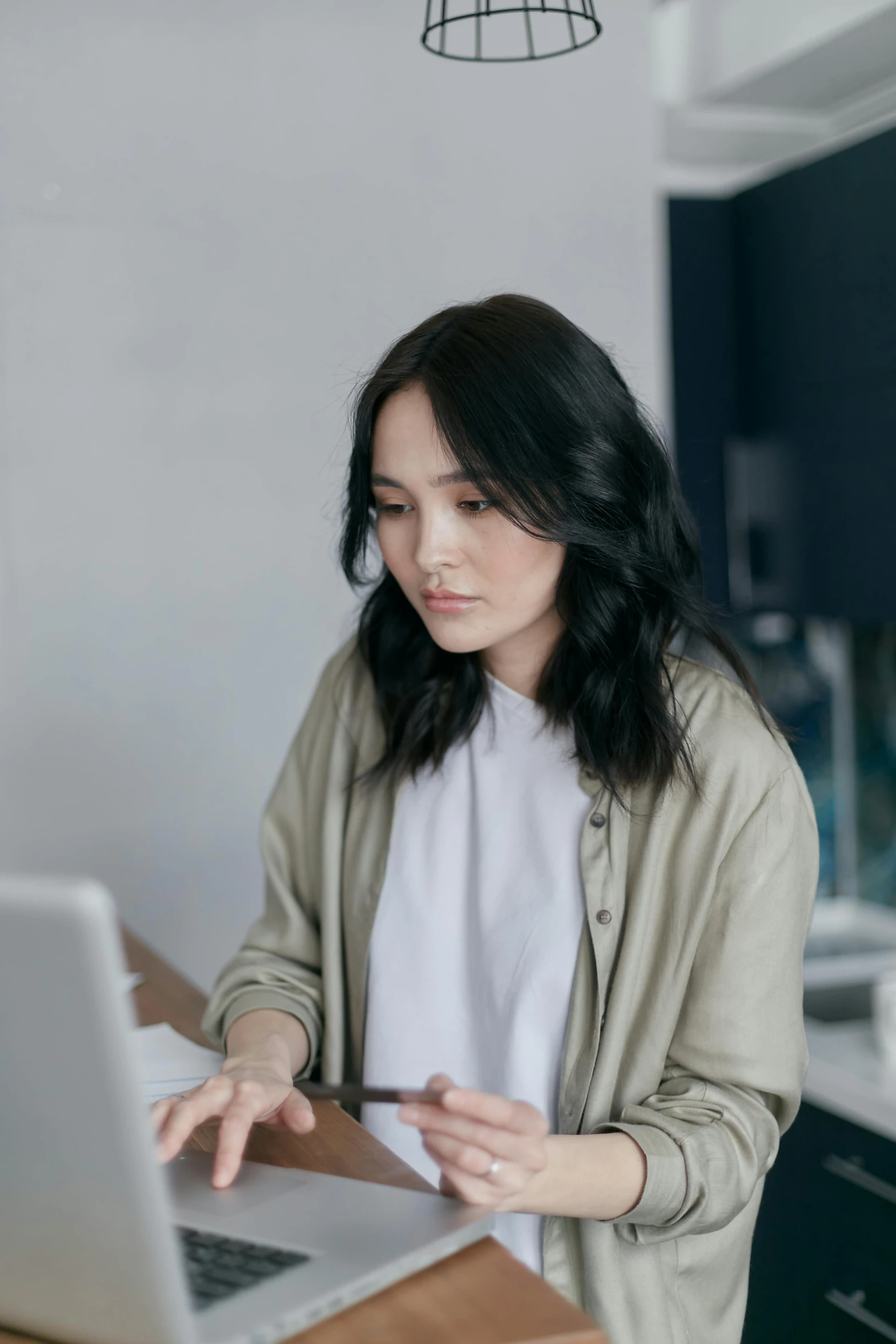 a woman sitting at a table using a laptop computer, trending on pexels, asian girl with long hair, professional photo, grey, gif