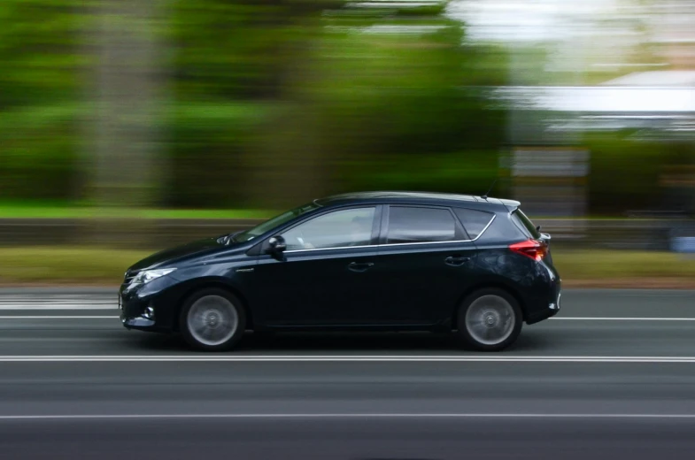 a black car driving down a city street, side profile shot, square, proportional image, fan favorite