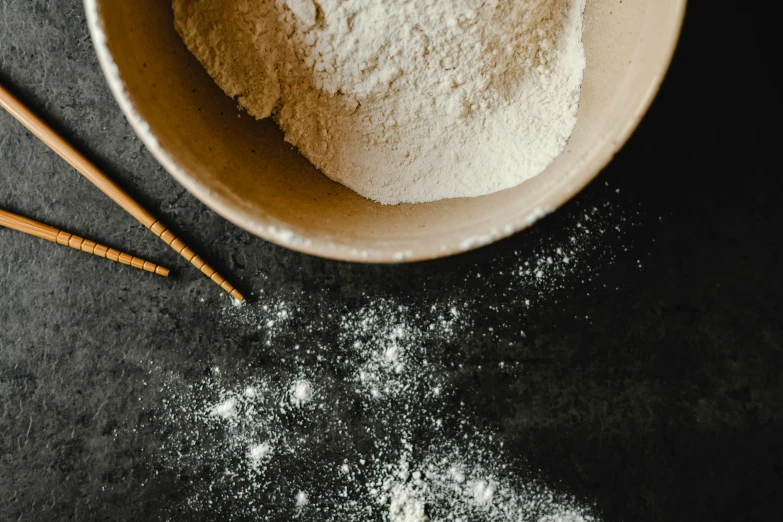 a bowl of flour and chopsticks on a table, inspired by Tani Bunchō, trending on pexels, background image, chalk, neck zoomed in, thumbnail