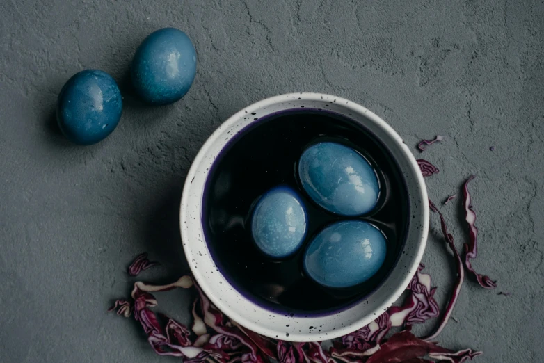 a bowl filled with blue eggs sitting on top of a table, inspired by Elsa Bleda, unsplash contest winner, renaissance, made of wax and water, violet polsangi, soup, high quality product image”