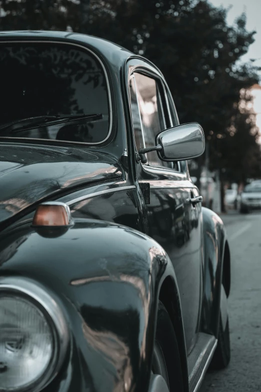 a black car parked on the side of the road, pexels contest winner, photorealism, beetle-inspired, side light, 15081959 21121991 01012000 4k, in gunmetal grey