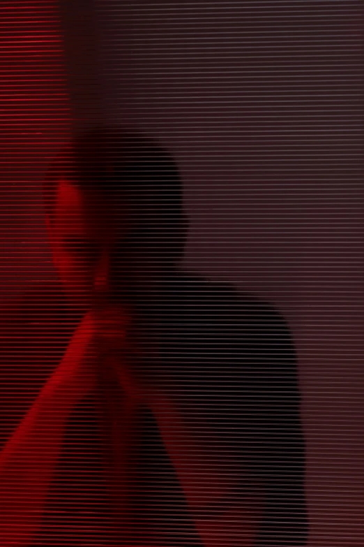 a man standing in front of a red screen, by Attila Meszlenyi, conceptual art, sorrow intense likely, glitch, man sitting facing away, gif