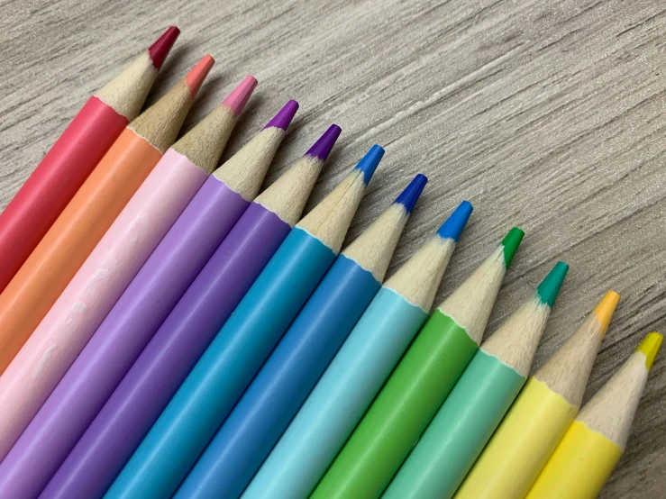 a group of colored pencils sitting on top of a wooden table, instagram post, colourised, pearlescent, matte finish