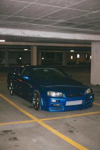 a blue car parked in a parking garage, by An Gyeon, trending on reddit, in a modified nissan skyline r34, low quality photo, ✨🕌🌙, convertable