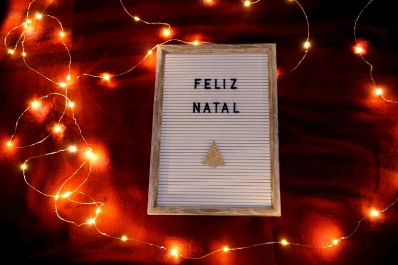 a sign that says feliz natall surrounded by christmas lights, pexels, folk art, background image, whiteboards, brown, post - minimalism