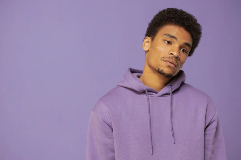 a man in a purple hoodie poses for a picture, trending on pexels, renaissance, pastel clothing, basic background, in colour, no - text no - logo