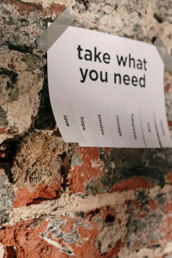 a sign attached to a brick wall that says take what you need, a poster, by Niko Henrichon, trending on pexels, occasional small rubble, profile image, diverse, wondering about others