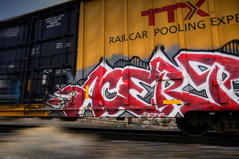 a train with graffiti on the side of it, pexels contest winner, scarlet and yellow scheme, acid graphix, action sports, lettering clean
