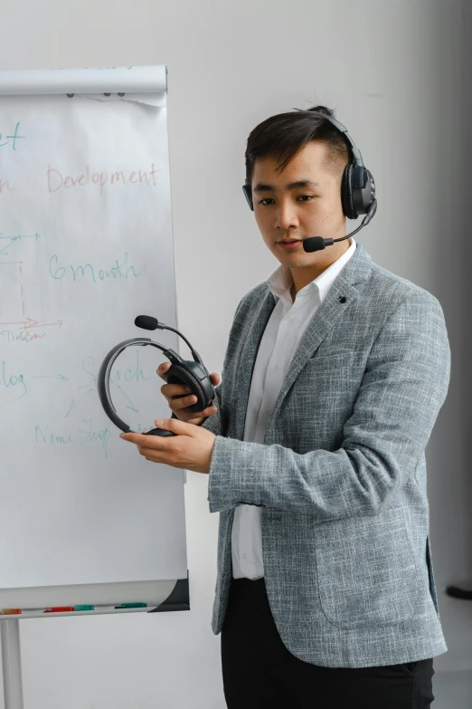 a man wearing a headset standing in front of a whiteboard, pexels contest winner, dao trong le, male with halo, wearing business casual dress, wearing modern headphone