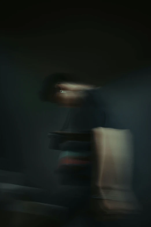 a blurry photo of a person in a dark room, an album cover, inspired by Anna Füssli, pexels contest winner, conceptual art, he is carrying a black briefcase, the librarian, eyes still visible, exiting store