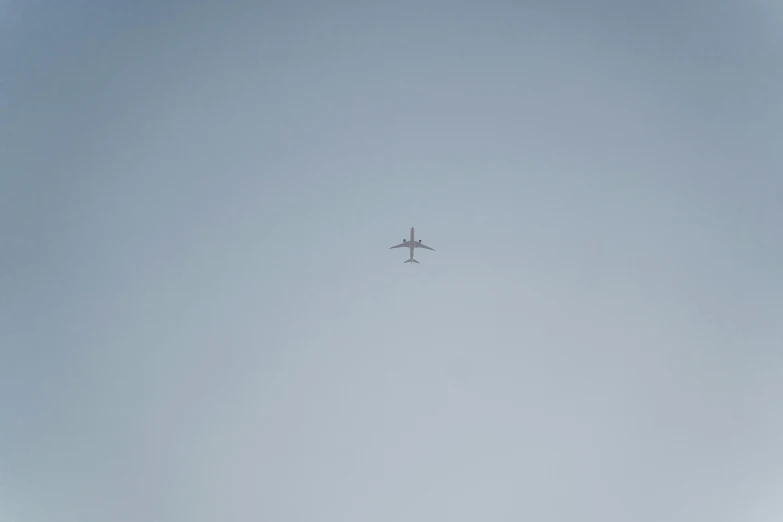 an airplane is flying high in the sky, unsplash, minimalism, minimalistic!! simple, pareidolia, low quality footage