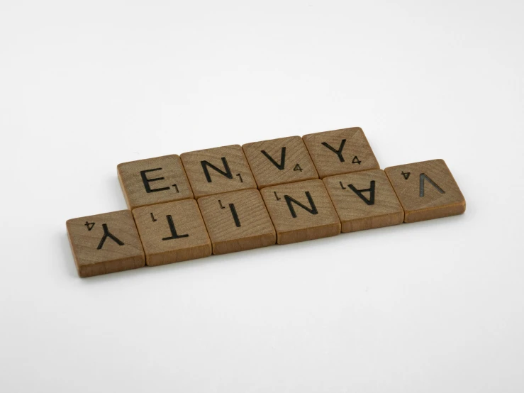 a close up of scrabbles on a white surface, inspired by Cerith Wyn Evans, letterism, brown, official product photo, eternal, engraved