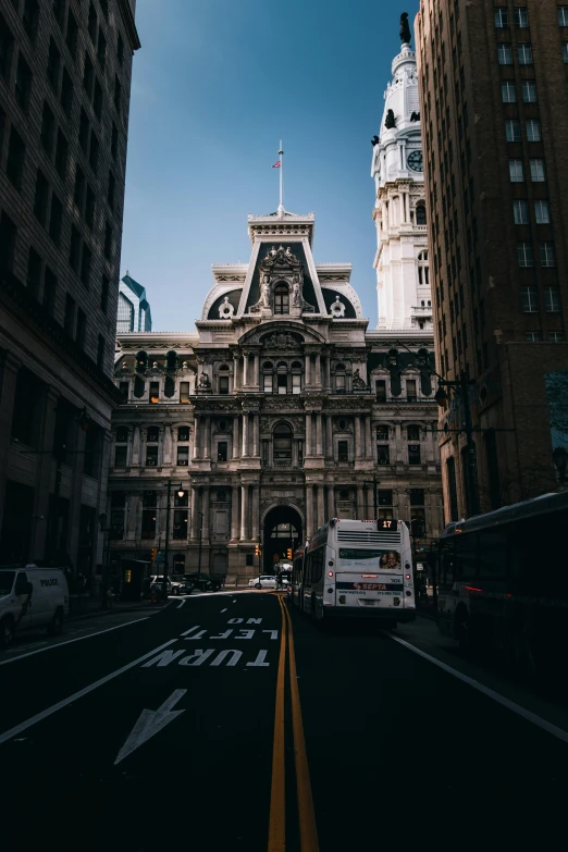 a city street lined with tall buildings and a clock tower, a photo, pexels contest winner, renaissance, always sunny in philadelphia, rococo architecture, intersection, mansion