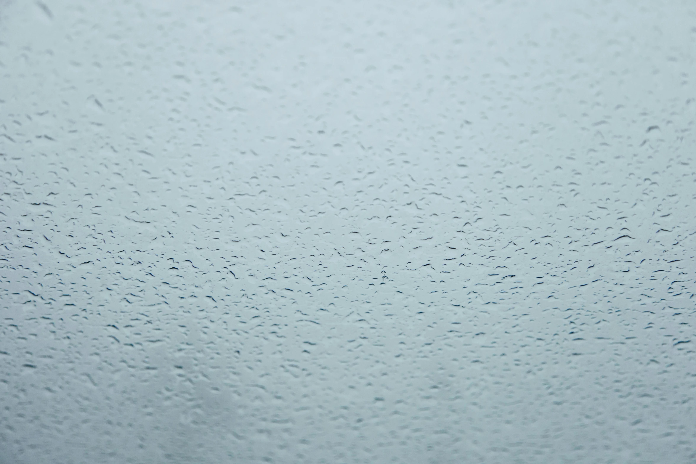 a close up of water droplets on a window, pexels, minimalism, background image, pale blue fog, smooth surface render, solid grey