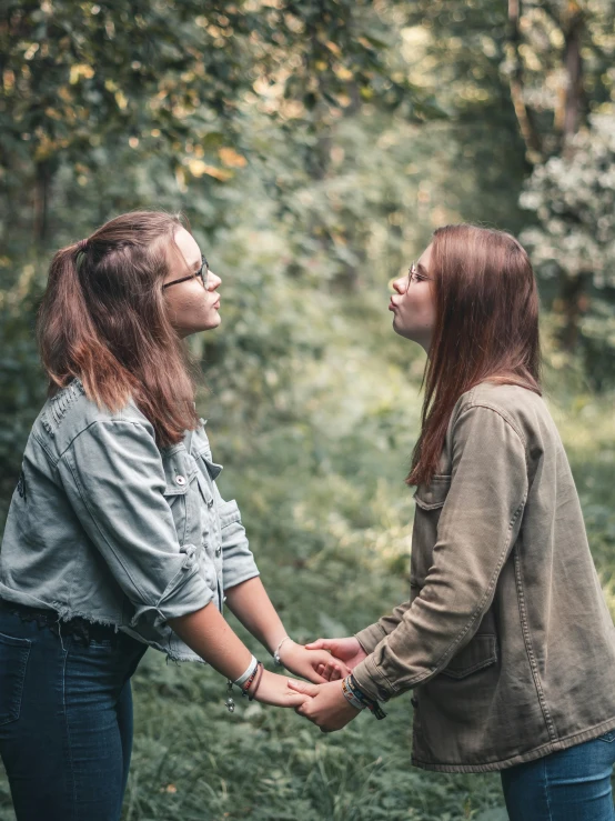 two women holding hands in the woods, a photo, trending on pexels, lesbian kiss, calmly conversing 8k, teenager, profile image