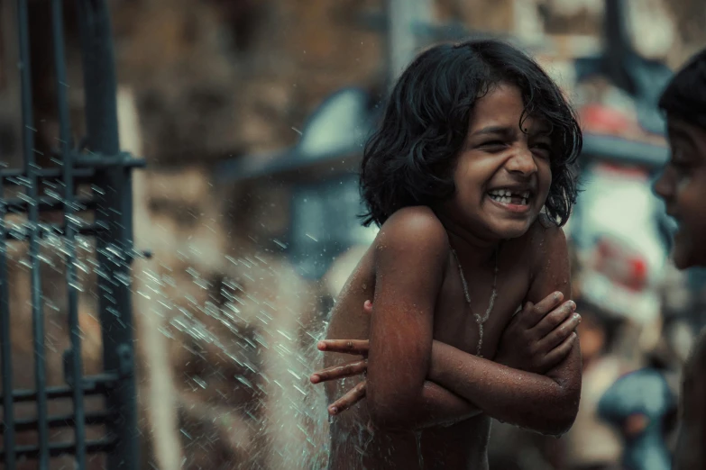 two children playing with a sprinkle of water, an album cover, pexels contest winner, indian girl with brown skin, brutal joyful face expression, [ cinematic, hd wallpaper