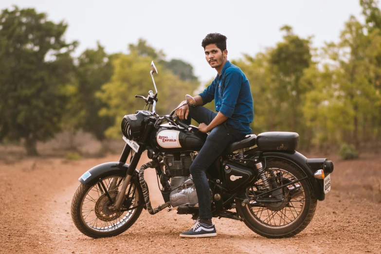 a man sitting on a motorcycle on a dirt road, pexels contest winner, indian super model, casual pose, avatar image, college