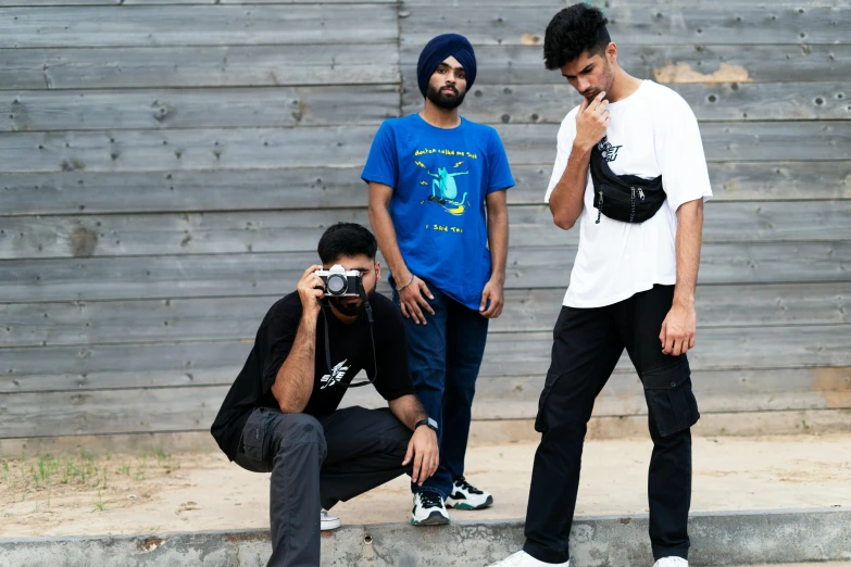 a group of young men standing next to each other, inspired by Manjit Bawa, pexels contest winner, visual art, wearing pants and a t-shirt, avatar image, eye level shot, wearing a baggy