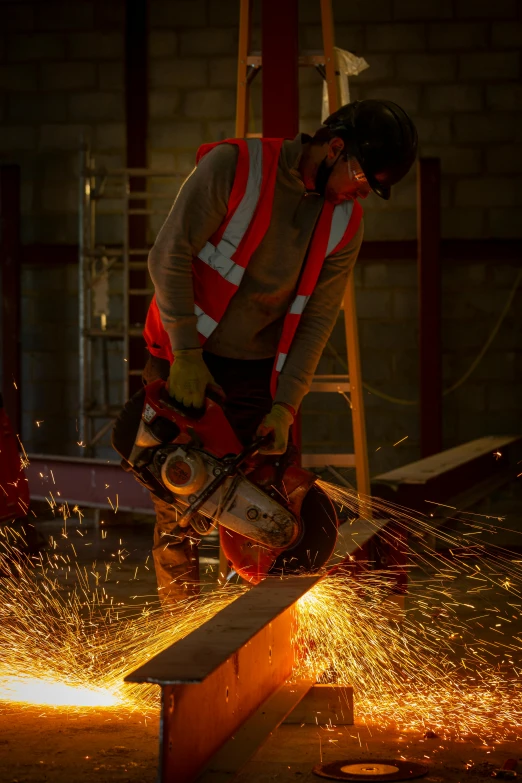 a man cutting metal with a circular saw, by Sam Black, wearing a red gilet, commercial lighting, full body hero, trending photo