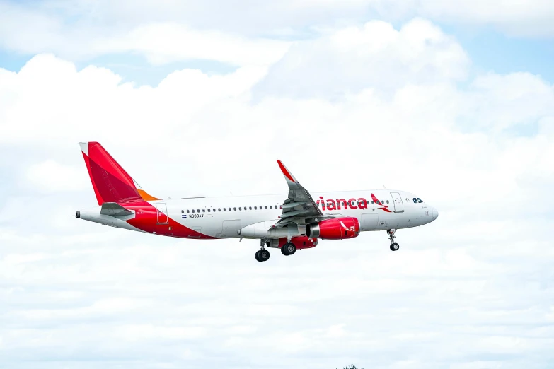 a large jetliner flying through a cloudy sky, by Daniel Lieske, pexels contest winner, renaissance, vibrant red, in spain, landing gear, replica model