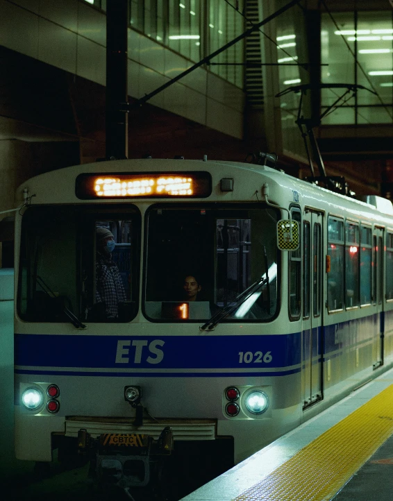 a train pulling into a train station next to a platform, minneapolis, transgender, evan lee, photograph