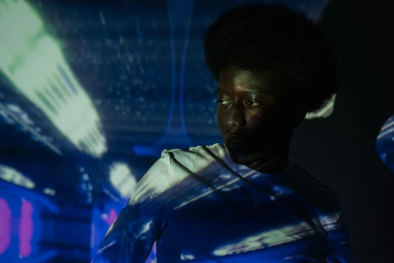 a woman standing in a dimly lit room, afrofuturism, bursting with blue light, ignant, black man with afro hair, photograph of three ravers