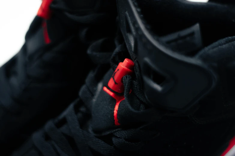 a pair of black and red sneakers on a white surface, by Sebastian Vrancx, trending on pexels, detailed pistol trigger, micro detail 4k, air jordan 1 high, red glowing veins