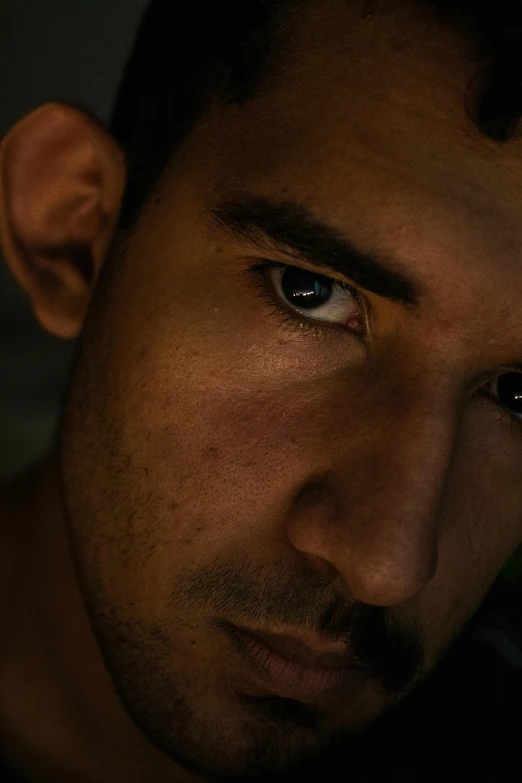 a close up of a man looking at the camera, pexels contest winner, an afghan male type, dimly lit scene, young spanish man, concerned