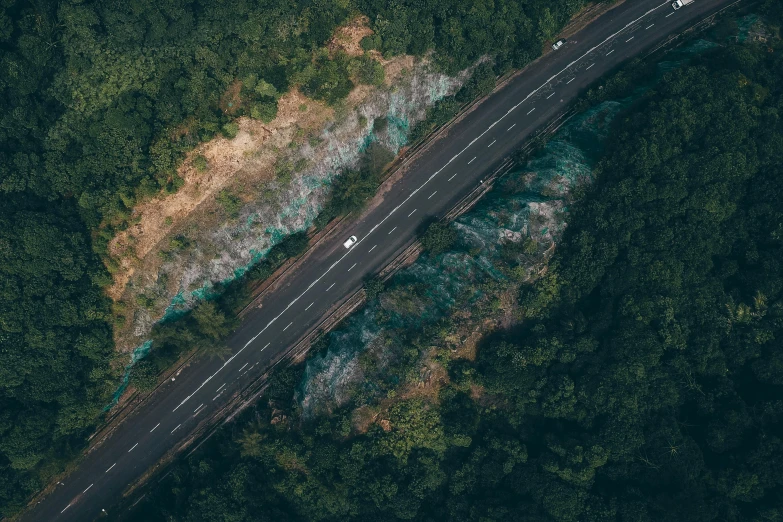 an aerial view of a road in the middle of a forest, pexels contest winner, hurufiyya, thumbnail, feature, vehicle, cliffside