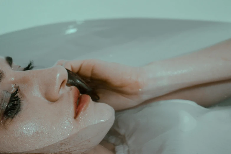 a woman laying in a bathtub talking on a cell phone, inspired by Elsa Bleda, trending on pexels, aestheticism, smothered in melted chocolate, large lips, goth girl aesthetic, candy treatments