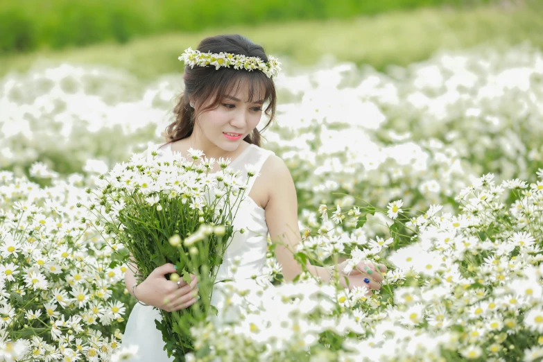 a woman holding a bunch of flowers in a field, a picture, inspired by Kim Du-ryang, pixabay, white flowers on the floor, vietnamese woman, wearing a wedding dress, avatar image