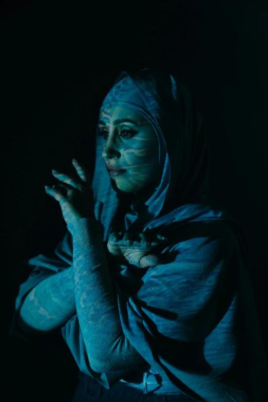 a woman with blue paint on her face and hands, an album cover, inspired by Godfried Schalcken, pexels contest winner, muslim, sidious, fullbody painting, ( ( theatrical ) )