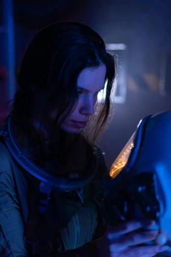 a woman using a laptop computer in a dark room, yellow space suit, portrait of anya taylor-joy, spaceship being repaired, slide show