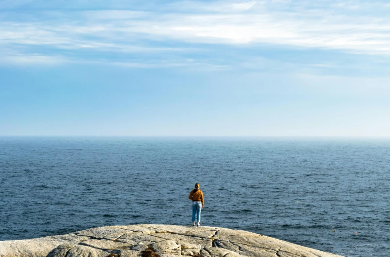 a person standing on top of a rock near the ocean, rhode island, manly, guide, outdoor photo