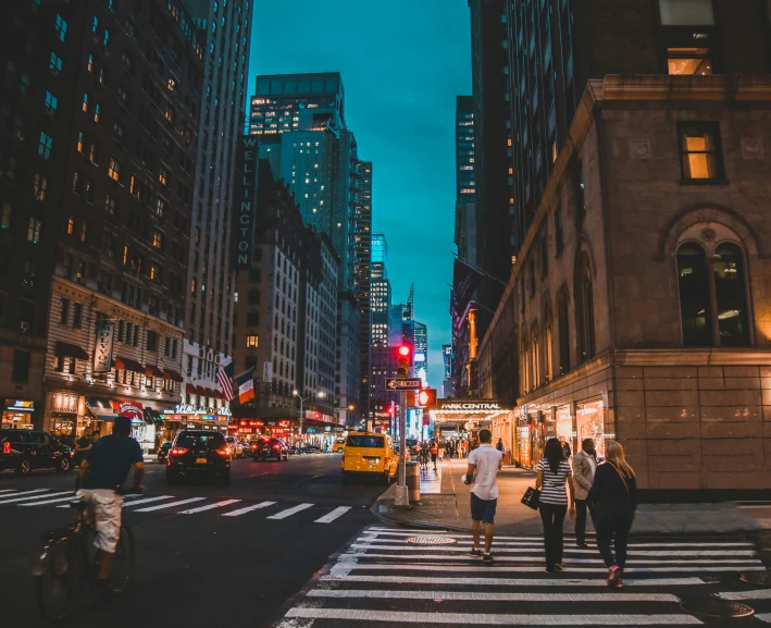 people walking across a city street at night, pexels contest winner, new york buildings, background image, street of teal stone, instagram photo