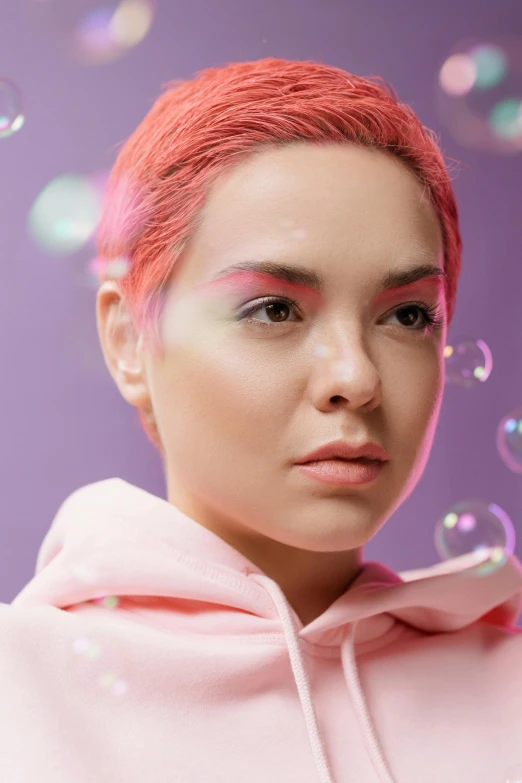 a woman in a pink hoodie blowing bubbles, an album cover, inspired by Pearl Frush, trending on pexels, pastel makeup, ariel perez, beauty campaign, dyed hair