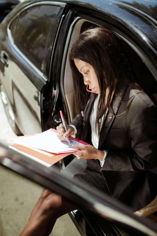 a woman sitting in a car writing on a piece of paper, girl in a suit, thumbnail, professional grade, multiple stories