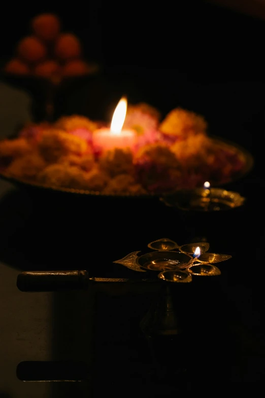 a lit candle sitting on top of a plate of food, hindu ornaments, torchlights, paul barson, glowing flowers