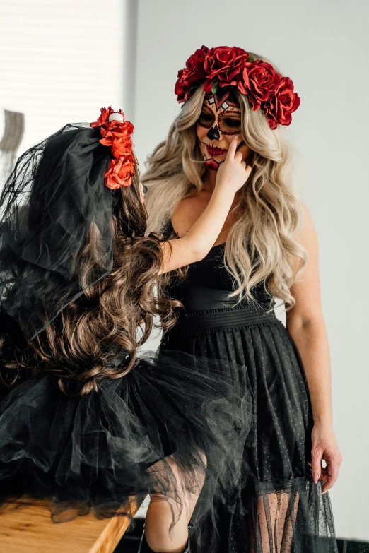 a woman wearing a black dress and a red flower crown, by Heather Hudson, trending on pexels, sugar skull, woman holding another woman, wearing a fancy dress, opening shot