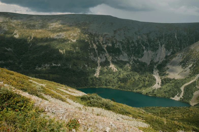 a large body of water sitting on top of a lush green hillside, by Emma Andijewska, unsplash contest winner, hurufiyya, red lake, lachlan bailey, on the mountain, 2 0 0 0's photo