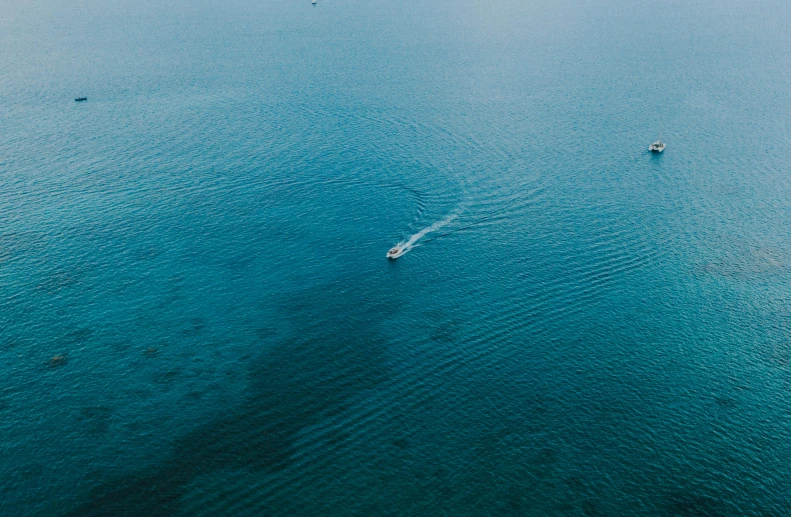 a group of boats floating on top of a large body of water, by Carey Morris, pexels contest winner, minimalism, deep blue water, thumbnail, detailed screenshot, cinematic full shot