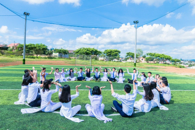 a group of people sitting on top of a soccer field, gutai group, ao dai, yoga, avatar image, space high school