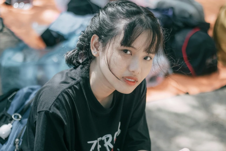 a woman sitting on the ground smoking a cigarette, by Tan Ting-pho, pexels contest winner, realism, wearing black tshirt, young adorable korean face, center parted bangs, headshot profile picture