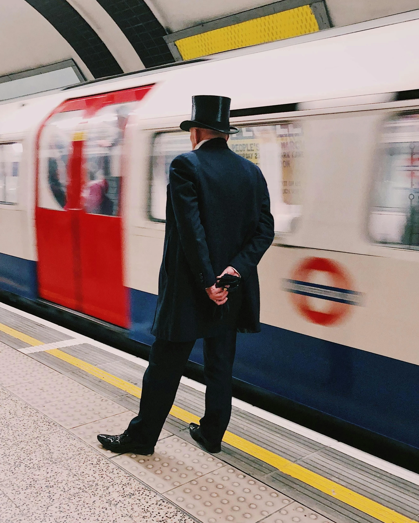 a man in a top hat standing in front of a train, by Adam Rex, unsplash, london underground tube station, instagram post, regency-era, lgbtq