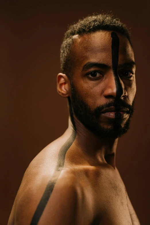 a man with a tattoo on his chest, an album cover, inspired by Thomas Blackshear, trending on pexels, portrait of combat dancer, headshot photograph, skin color, light and dark