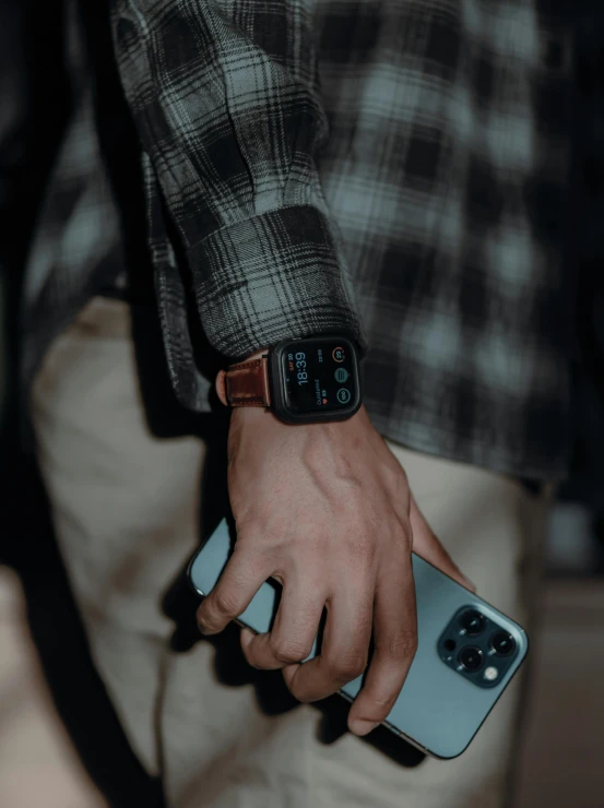 a close up of a person holding a cell phone, by Adam Marczyński, renaissance, leather cuffs around wrists, 8k 28mm cinematic photo, square, with apple