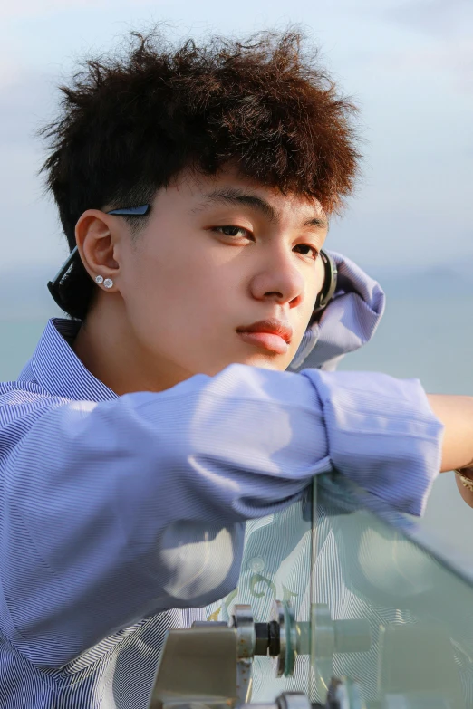 a close up of a person on a cell phone, an album cover, inspired by Yeong-Hao Han, ocean in the background, confident looking, genderless, profile posing