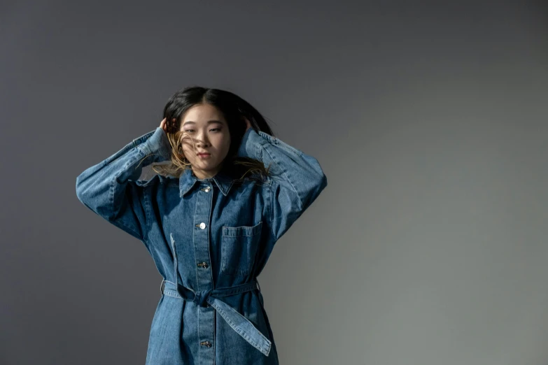 a woman in a denim dress posing for a picture, inspired by Kim Tschang Yeul, trending on pexels, bedhead, girl in raincoat, studio shot, celebrating